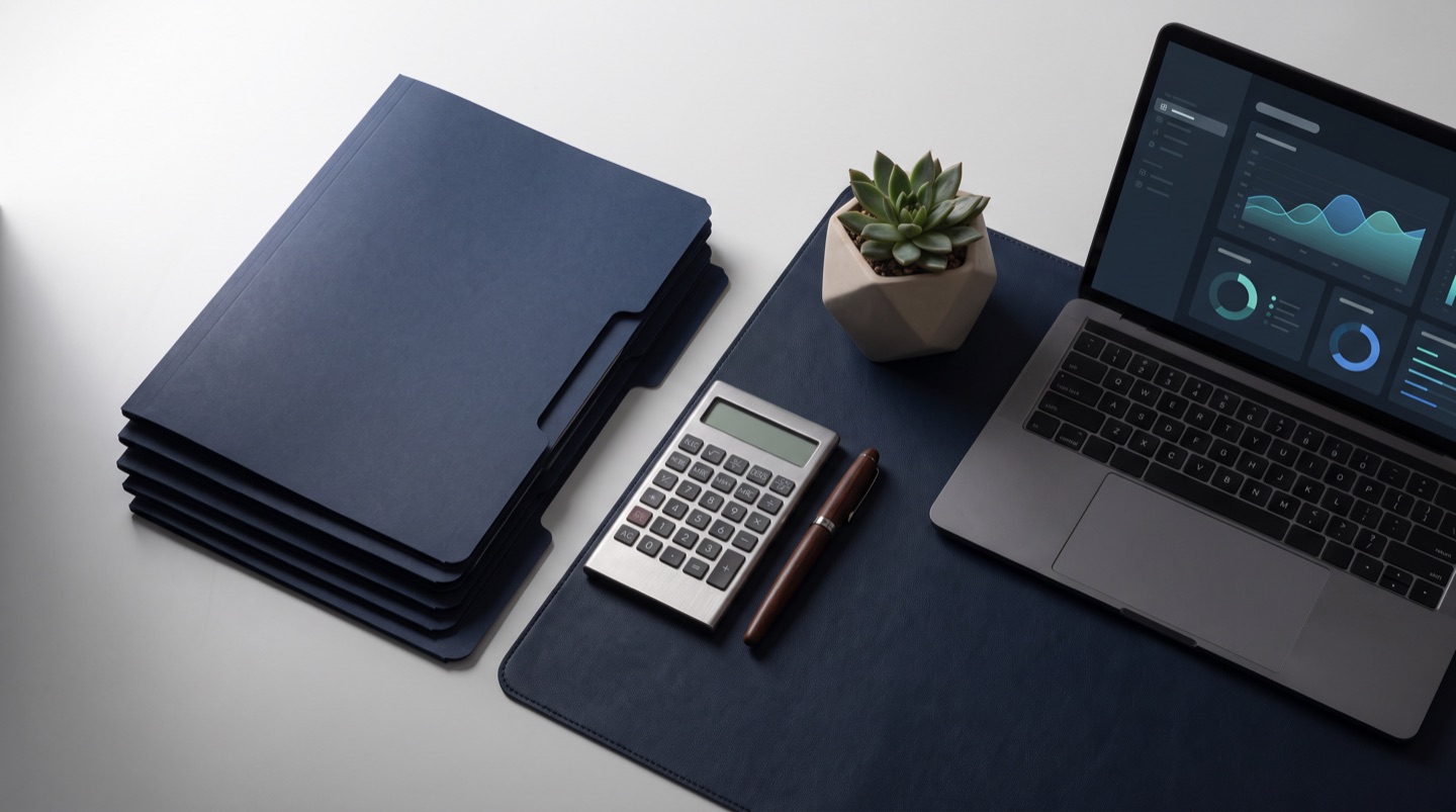 A payroll and statutory compliance desk with document folders, a calculator and a laptop